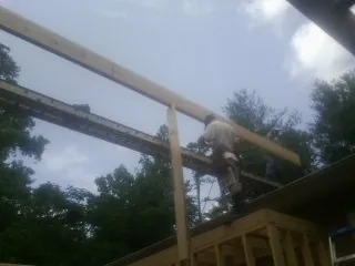 Carpenter setting a ridge beam over a new addition frame — Ice Dam Removal by Roofing Brothers in Sea Isle City