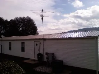 New metal roof on a single wide mobile home with a TV antenna in Sea Isle City