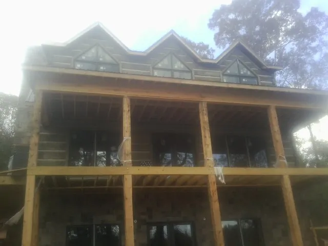 Dormers and porch framing on a large log home under construction — Roof Coating work by our crew in Sea Isle City